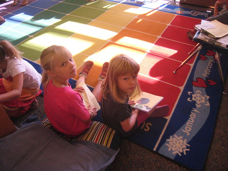 img_6272 Zoe and Sela reading before class starts. They don't look so happy, but I think they're very excited.